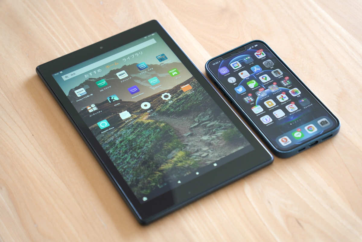 Amazon fire HD 10本体をiPhone12 Pro Maxと並べて大きさを比較している様子の画像